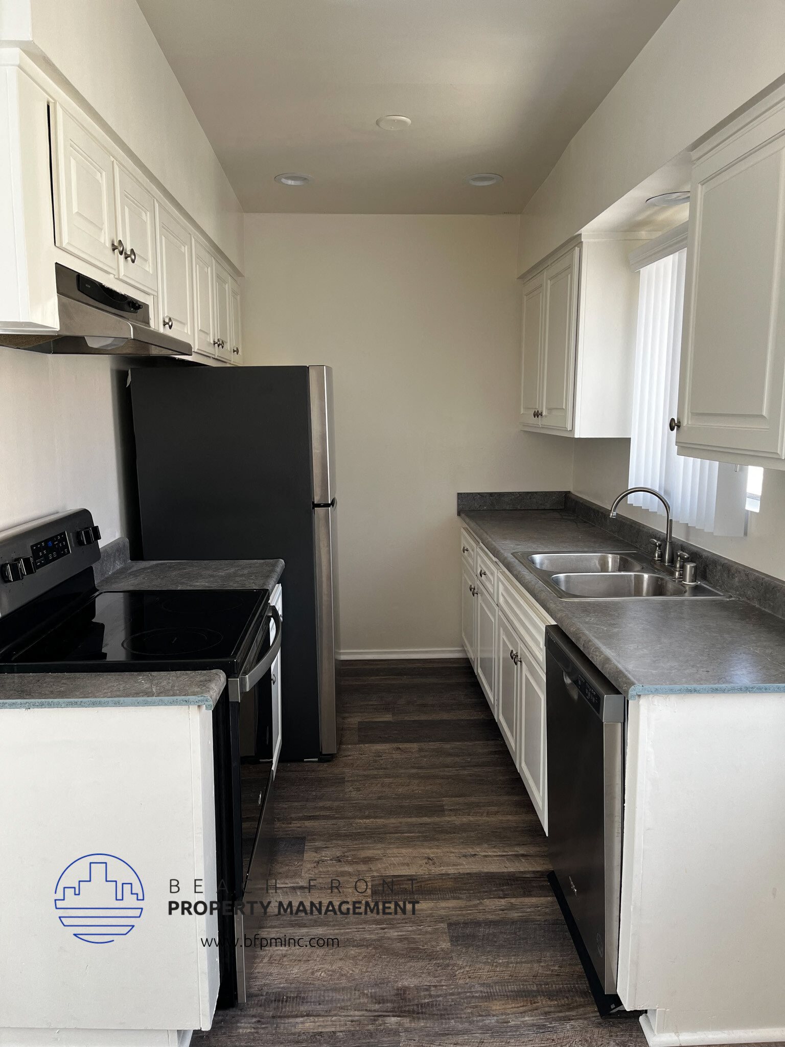 a kitchen with white cabinets and black appliances